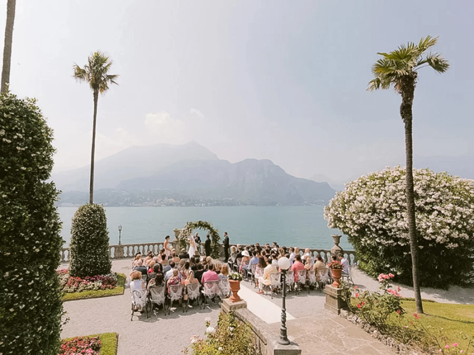 Freie Trauung mit Seeblick und Palmen am Comer See, Hochzeitsgäste auf der Gartenterrasse