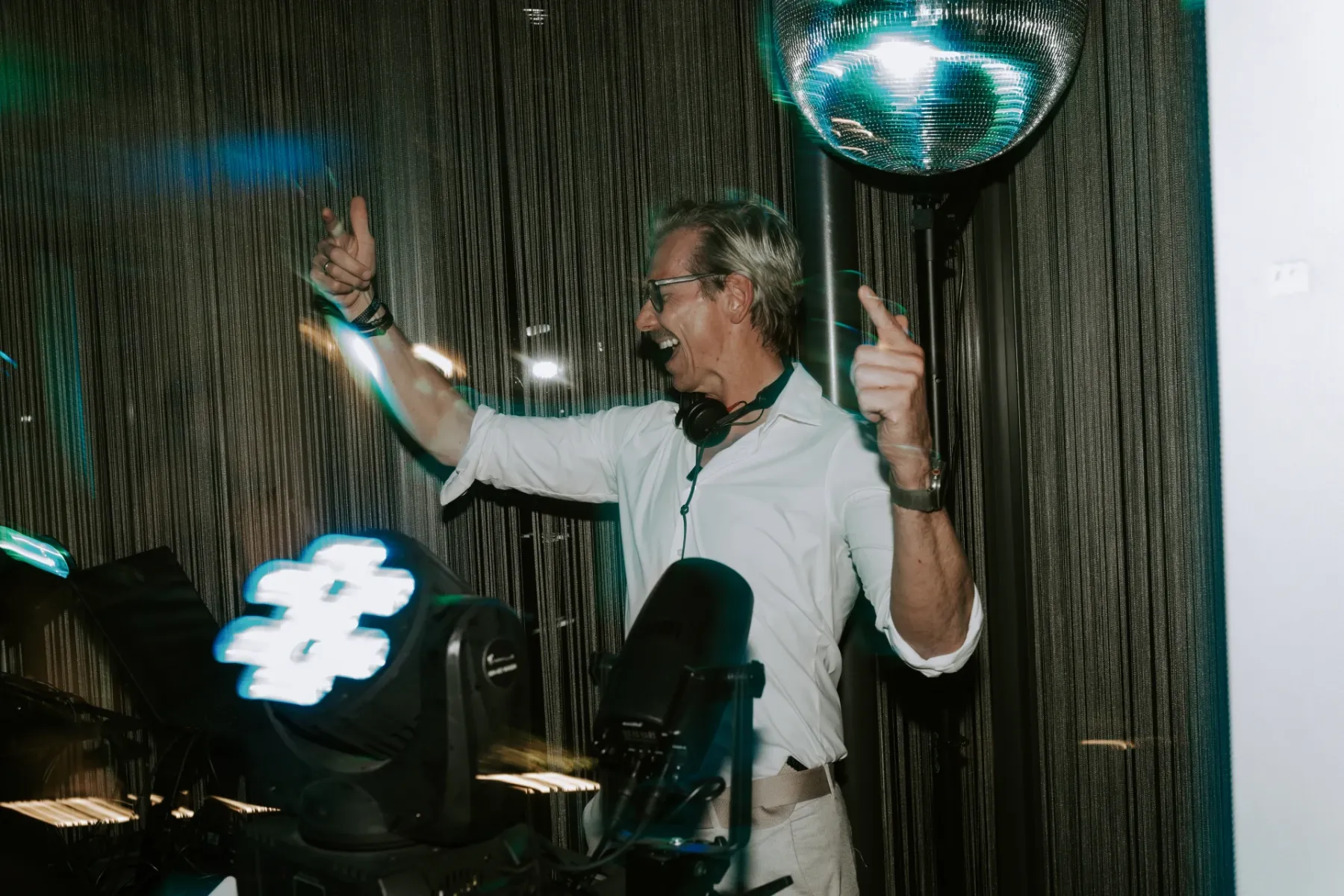 Alex Maus an der Discokugel auf einem Event, Arme hoch, ausgelassene Partystimmung